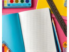 Offene Schulbücher und Schreibwaren auf einem Tisch